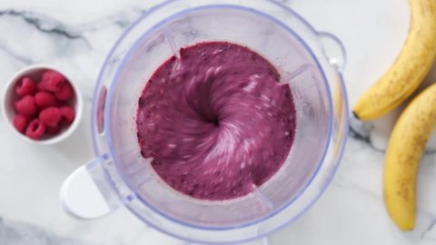 Purple blueberry smoothie mixing in blender. Preparing healthy berry smoothie
