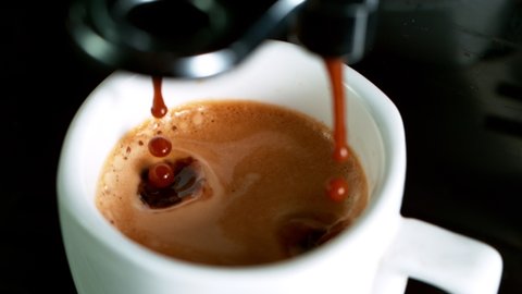 Close-up Slow Motion of Espresso Pouring from Coffee Machine. Filmed on High Speed Cinematic Camera at 1000 fps.