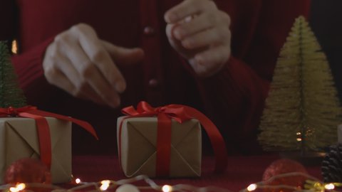 Woman hand untie ribbon at gift box on table for christmas and new year concept.