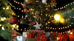 Many gift boxes and christmas decorations under a beautiful decorated christmas tree with bokeh lights in living room at night. - Powered by Shutterstock - Get 15% off with code: PIKWIZARD15