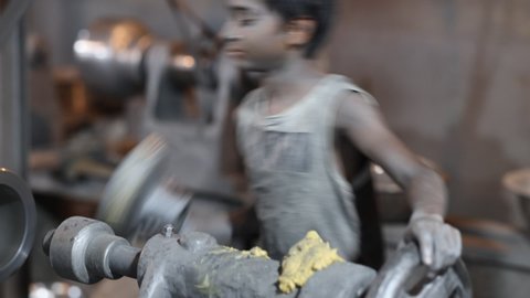 DHAKA, BANGLADESH - OCTOBER 10, 2020: In a toxic, dangerous and non compliant sweatshop, underaged workers are engaged in child labor not respecting occupational health and safety rules in a factory