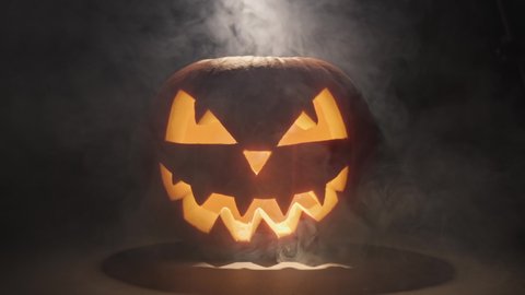 Traditional Halloween symbol. Halloween pumpkin smile and scary eyes for party night. Horror Halloween concept. Pumpkin glows on Halloween night.