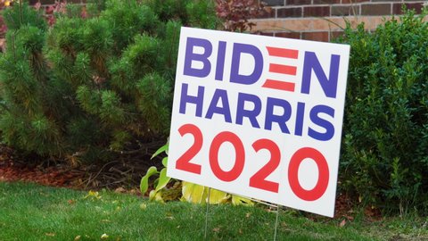 Young Man Takes Out of Ground Joe Biden Kamala Harris 2020 Yard Sign in Front Yard of House Close Up, Political