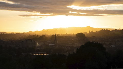 Golden sunset and sun rays over hilltops of Bath, Somerset UK timelapse