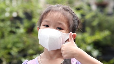 Supper slow motion little child girl wearing protective medical face mask. Practicing social distancing, Coranavirus COVID-19. Health Care and Virus Protection Concept.