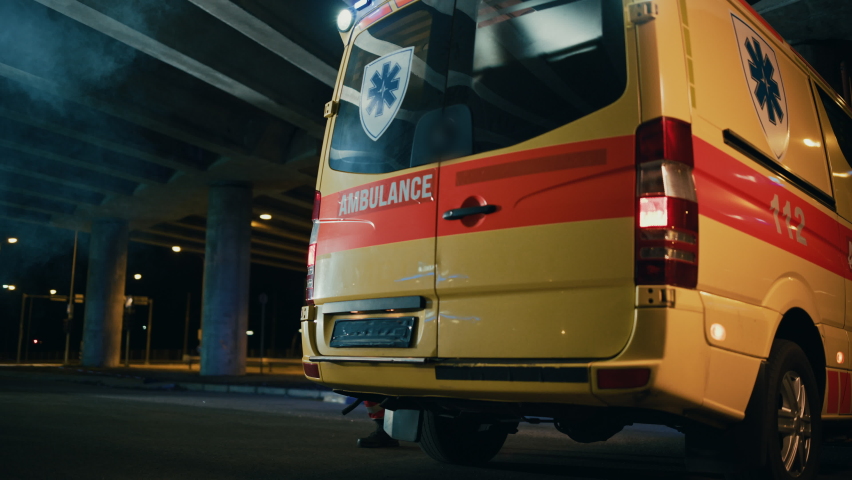 Team of EMS Paramedics Quickly Take Out a Stretcher from Ambulance Vehicle and Help an Injured Person. Emergency Care Assistants Arrived on the Scene of a Traffic Accident on a Street at Night. Royalty-Free Stock Footage #1060859467