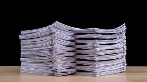 Stop motion animation Stacks overload document paper files on office desk isolated on black background, Business concept.