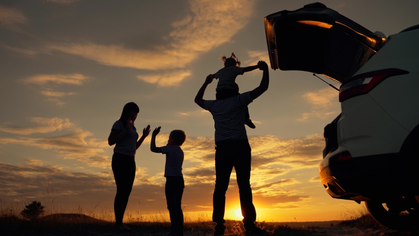 Happy family in the park. Silhouette of a happy family in the park at sunset. Parents play with their children at sunset. Silhouette of a group of people field. Happy family and vacation concept | Shutterstock HD Video #1060863040