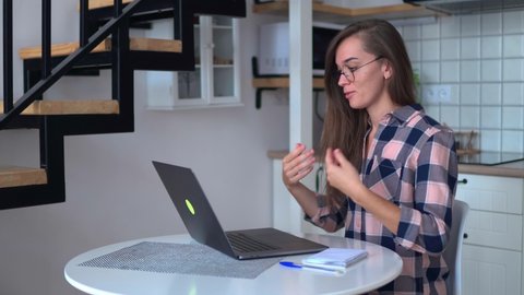 Young woman learning and communicates in sign language online at a computer at home