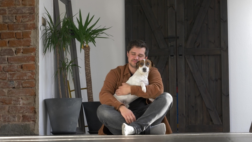 guy is playing with his dog on the floor