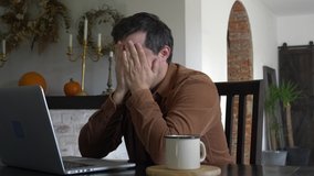 Man in depressing is working with laptop at home