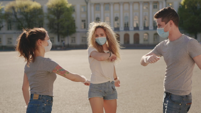 Social distancing. Multiracial Friends in protective face mask greet their elbows. Elbow bump is new greeting to avoid spread of coronavirus or covid-19 - Avoid or Stop handshakes due to pandemic Royalty-Free Stock Footage #1060865893