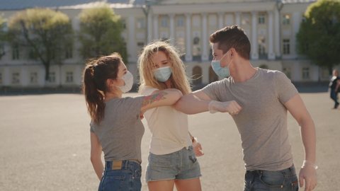 Social distancing. Multiracial Friends in protective face mask greet their elbows. Elbow bump is new greeting to avoid spread of coronavirus or covid-19 - Avoid or Stop handshakes due to pandemic