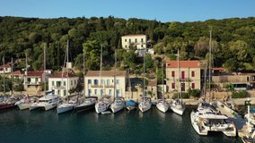 Aerial drone video of picturesque beautiful seaside village of Kioni a safe anchorage for yachts and sail boats, a true gem of Ithaki or Ithaca island, Ionian, Greece