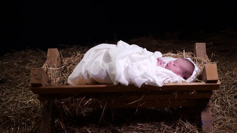 4K Dolly: Baby Jesus laying in a Manger with straw and Hay. Christmas Scene for the Nativity in a stable.