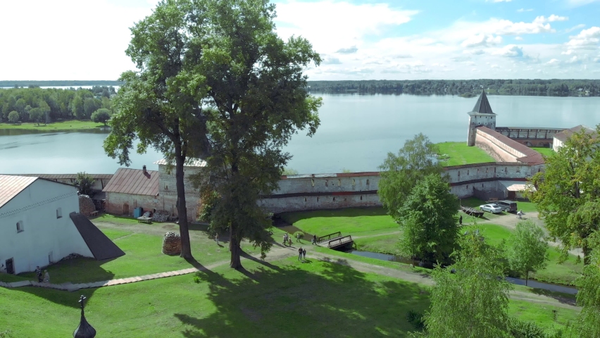 Kirillo Belozersky monastery in the Vologda region in Russia on the bank of the river on a sunny day. video filmed from the air by a drone on departure, focal length 24 mm