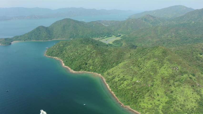 Aerial view of Hong Kong bay with lush green mountain terrains.