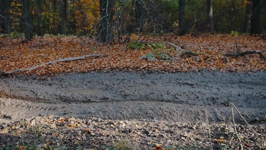 Outdoor activity - a man riding a red ATV in the forest - ride in the mud