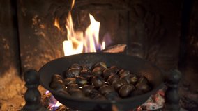 Roasting chestnuts in a frying pan on the fireplace. Celebrating "Castanyada, Castañada" typical dish and tradition of Catalonia, Spain, in All Saints Day. - Powered by Shutterstock - Get 15% off with code: PIKWIZARD15
