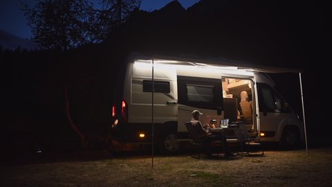 Caucasian Men Staying Overnight on a Camping and Working From Outside on His Laptop Computer and Internet Connection