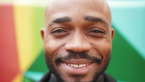 Close up portrait smiling face african american man looking at camera. Handsome confident man on the street urban.