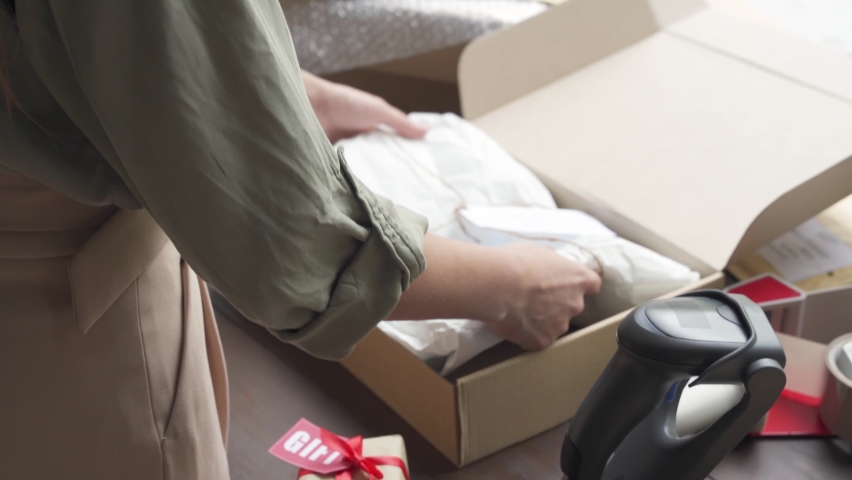 Female online store small business owner worker packing package post shipping ecommerce retail order gift in box preparing forwarding delivery parcel on table. Drop ship service concept, close up view Royalty-Free Stock Footage #1060888639