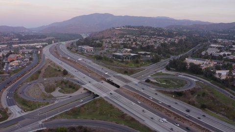 Twilight aerial view of the 91 Freeway through the community of Anaheim Hills in Anaheim, California, USA.