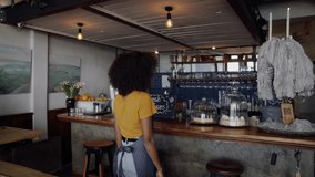 Clip of exquisite mixed raced cafe owner smiling crossed armed standing in trendy coffee shop.