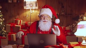 Happy Santa Claus holding gift box video calling kid talking to child in virtual video online chat meeting on laptop sit at home table late with present on xmas eve. Merry Christmas social distance. - Powered by Shutterstock - Get 15% off with code: PIKWIZARD15