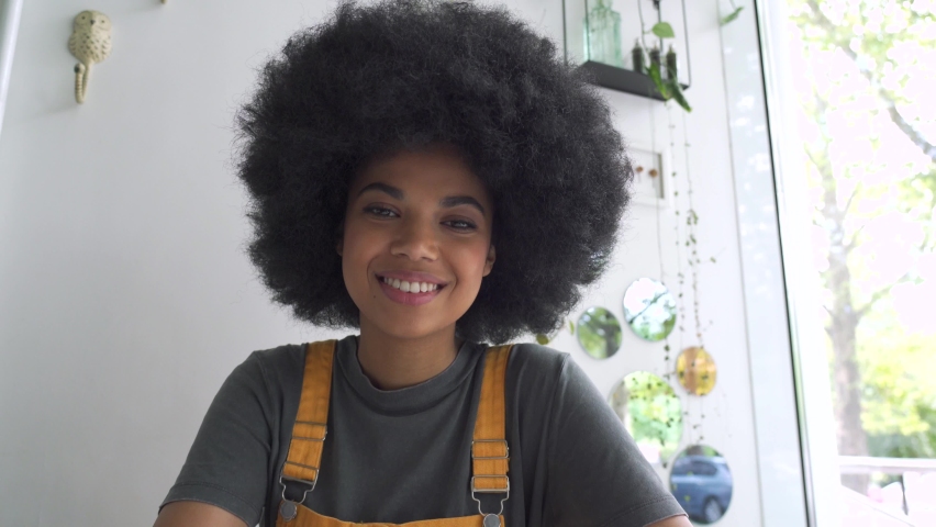 Young happy African American mixed race hipster vlogger woman waving hand looking at webcam talking to camera sit at table video conference calling in virtual chat meeting with social distance friend. Royalty-Free Stock Footage #1060892485