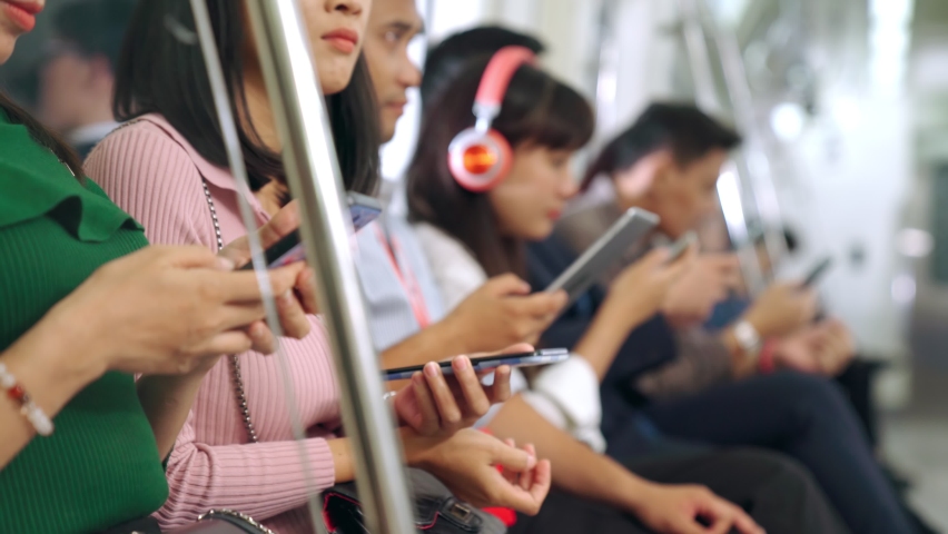Young people using mobile phone in public underground train . Urban city lifestyle and commuting in Asia concept . | Shutterstock HD Video #1060898401
