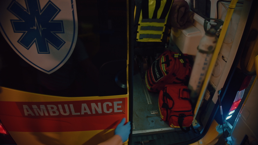 Footage from Above of a Team of EMS Paramedics Bringing Injured Patient to Hospital and Get Him Out of Ambulance on a Stretcher. Emergency Care Assistants Help Young Man to Stay Alive After Accident. Royalty-Free Stock Footage #1060901071