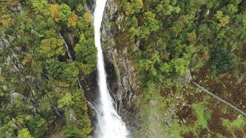 Idyllic Snowdonia mountain range Aber falls waterfalls national park aerial view rising pull away