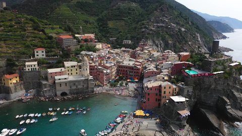 Low aerial orbit view of the historic fishing town of Vernazza, a world heritage site on the Italian coast.