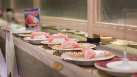 Kyoto / Japan - 03 04 2019: Plates Of Fresh Sushi On A Conveyor Belt In A Kaitenzushi Restaurant (Conveyor Belt Sushi) In Kyoto, Japan. - close up shot