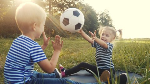 children in the park playing ball. happy family camping kid dream concept. brother and sister kid throw a ball each other fun play silhouette . girl kid on park relaxing dream in nature outdoors