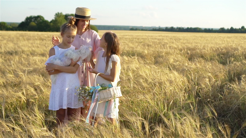 Happy mother and her little daughters on summer day