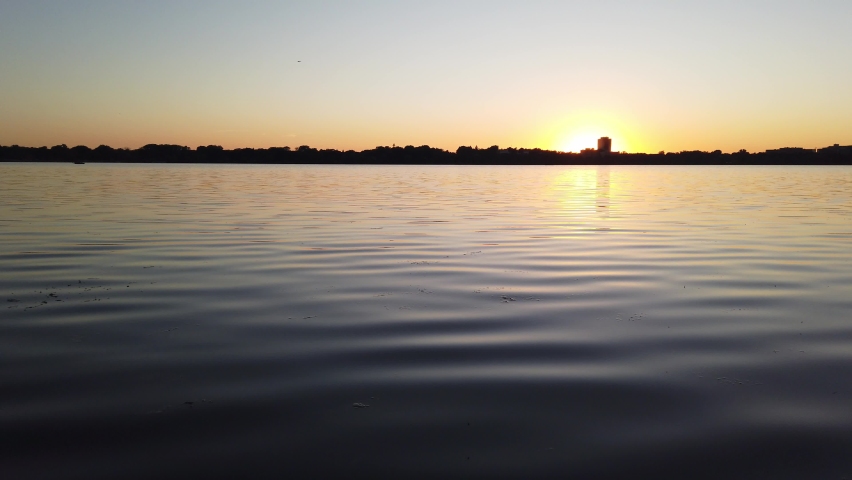 sun setting over the horizon seen from a lake in minnesota summer time