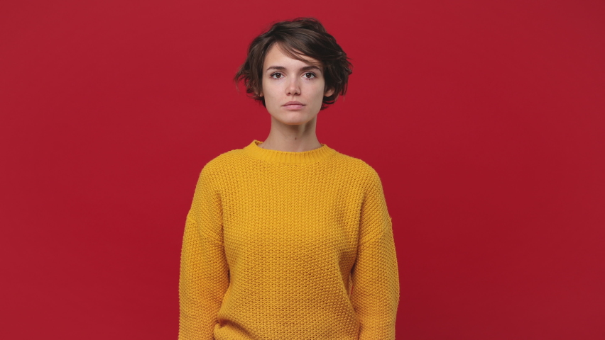 Fun young woman 20s years old in yellow sweater isolated on red wall background in studio. People lifestyle concept. Looking camera pointing fingers herself ask say who me no thanks i do not need it Royalty-Free Stock Footage #1060922215