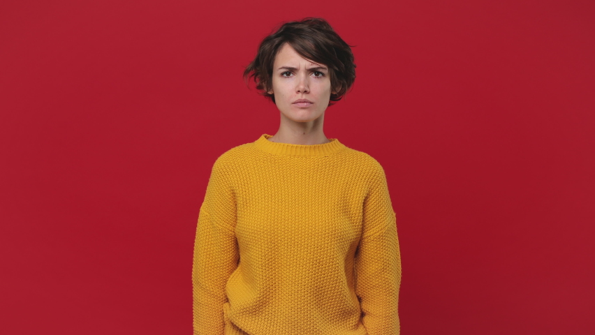 Angry mad young woman 20s years old in yellow sweater posing isolated on red background in studio. People sincere emotions lifestyle concept. Looking at camera screaming scolding protest waving hands Royalty-Free Stock Footage #1060922242