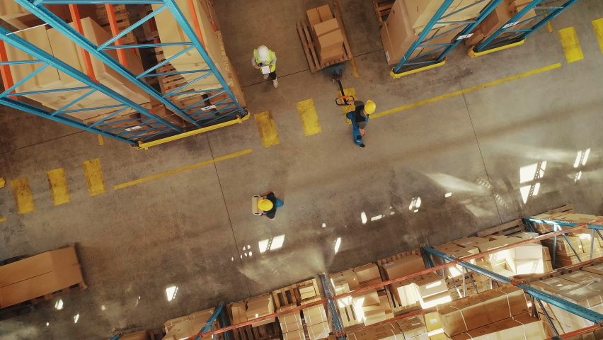 Top-Down View: In Warehouse People Working, Forklift Truck Operator Lifts Pallet with Cardboard Box. Logistics, Distribution Center with Products Ready for Global Shipment, Customer Delivery | Shutterstock HD Video #1060923313