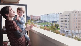 4k video of mother and son clapping on the balcony in gratitude to the doctors