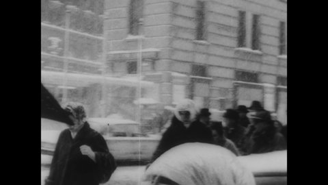 CIRCA 1961 - New Yorkers go about their regular routine as best they can during a blizzard in Manhattan, with children sledding in the streets.