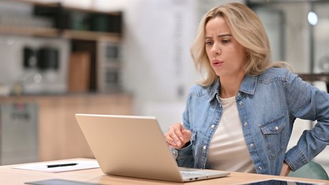 Young Casual Woman with Back Pain using Laptop at Work 