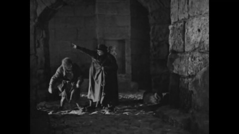 CIRCA 1923 - In this silent movie adaptation of the Hunchback of Notre Dame, Jehan stalks Esmeralda at night and has Quasimodo try to grab her.