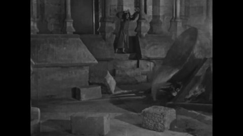 CIRCA 1923 - In this silent movie adaptation of the Hunchback of Notre Dame, Quasimodo (Lon Chaney) pours molten lead on the mob invading Notre Dame.