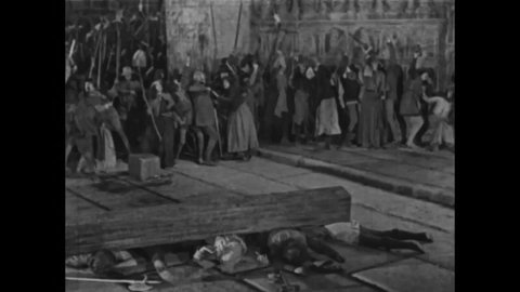 CIRCA 1923 - In this silent movie adaptation of the Hunchback of Notre Dame, invaders use a battering ram to break down Notre Dame's doors.