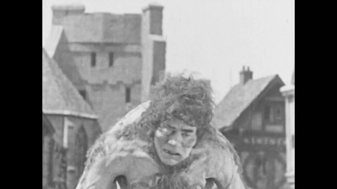 CIRCA 1923 - In this silent movie adaptation of the Hunchback of Notre Dame, Quasimodo (Lon Chaney) is chained and beaten before a jeering crowd.