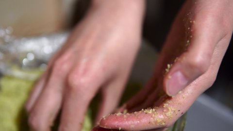 Woman making falafel balls from a mixture of chickpeas, spices and herbs. Close-up shot hands in slow motion.