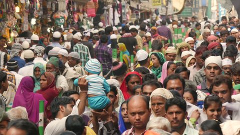 AJMER, INDIA - 30 OCTOBER 2014: Colorful crowds of mostly Muslim men and women walk through a busy bazaar. Many of them are on their way to the Dargah shrine, an important place of worship in Ajmer.